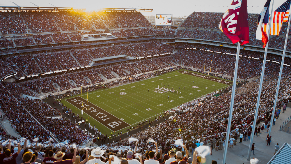 Wide shot of Kyle Field with full of audience watching a football game.