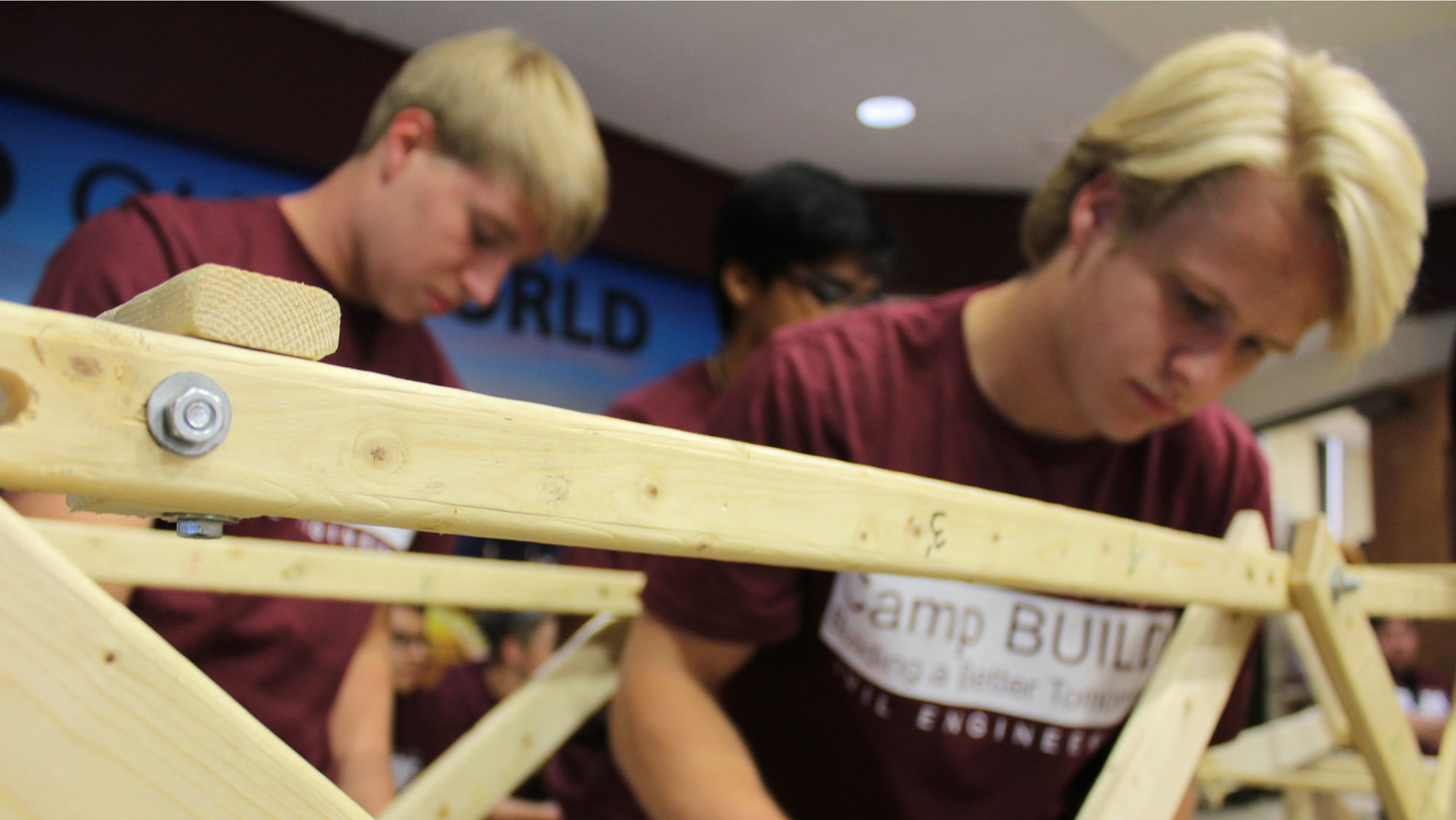 Students work during the Camp BUILD event on bridge construction.