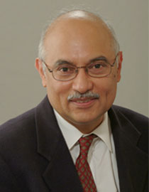 P.R. Kumar shown smiling and wearing a shirt, suit and tie