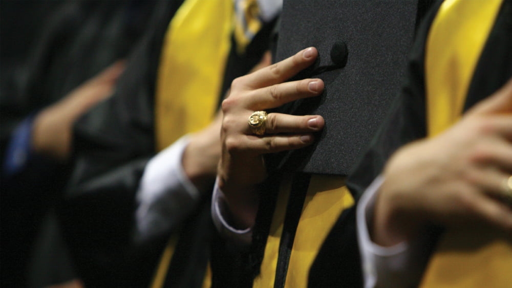 Student at graduation close up of their Aggie ring.