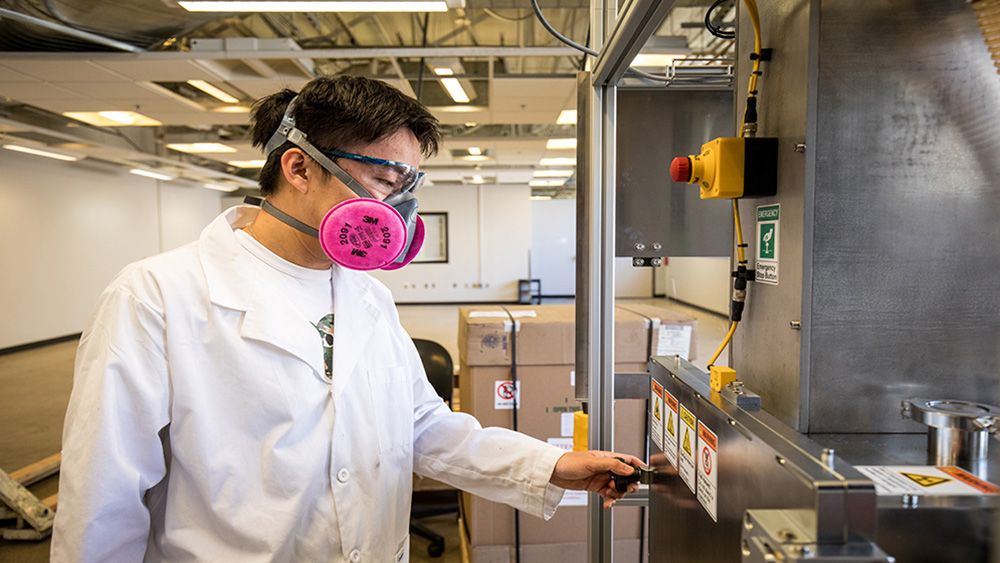 Scientist working in a lab wearing a mask.