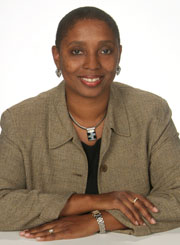 African American woman in olive green blazer posed for formal portrait.