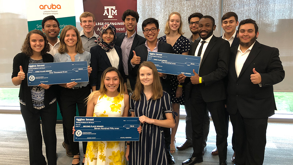 The winning teams from Aggies Invent pose for a photo with their large checks