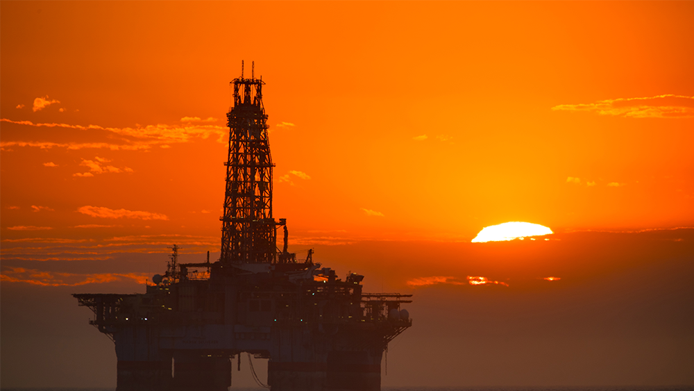 A deepwater oil drilling rig at sunset.