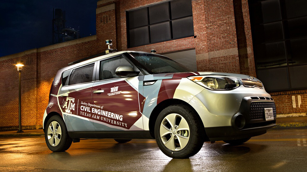 Autonomous vehicle is parked in front of a building with the Department of Civil and Environmental Engineering logo across the passenger front and back doors.