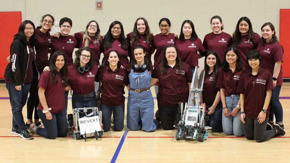 VEX teams smile at the camera with their robots.