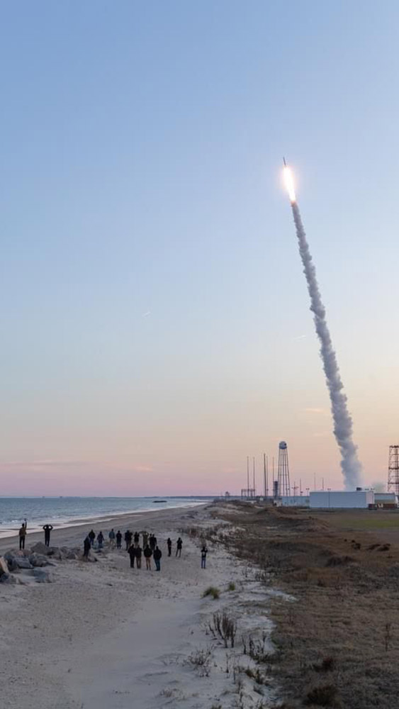 Researchers on the beach watching the BOLT II sounding rocket in mid-air after launch.