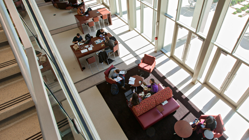 An aerial photo of students studying in the building, sitting at tables and on couches.