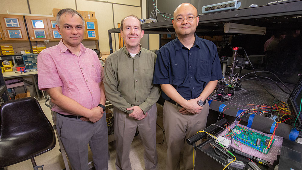 Left to right: Dr. Kamran Entesari, Dr. Sam Palermo and Dr. Pao-Tai Lin posing for group photo next to lab equipment