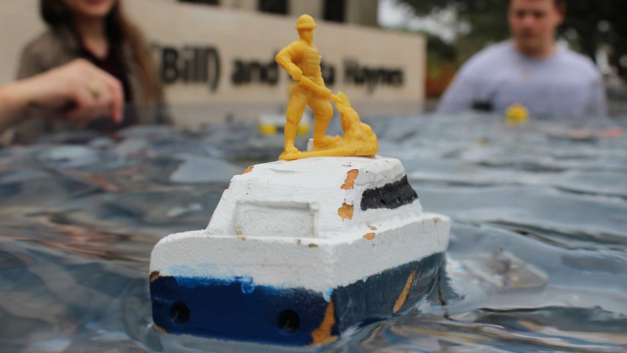 ocean engineering student organization demonstrates OCEN concepts using a pool and model boat