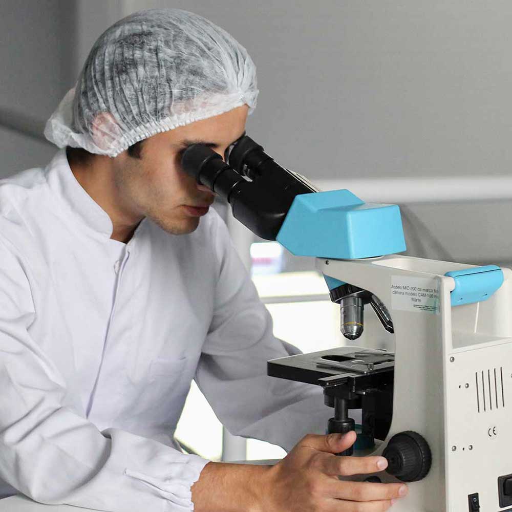 Student laboratory technician using an upright microscope.