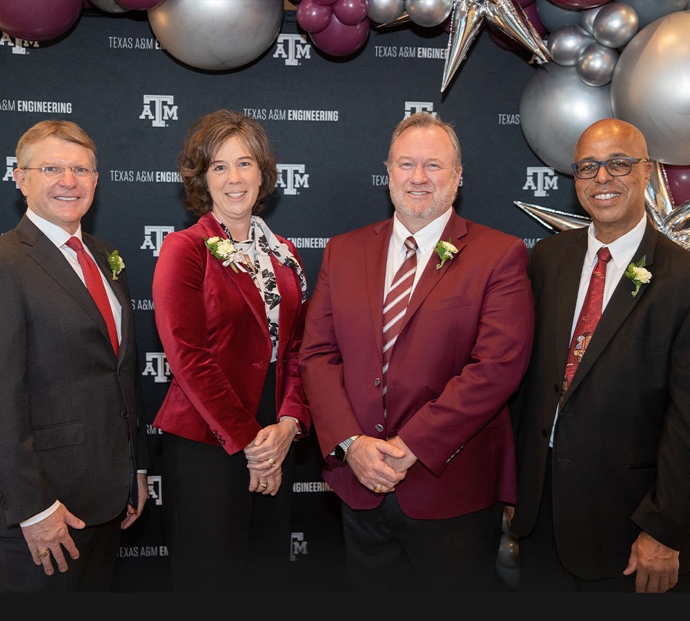 The four TAMU 2022 outstanding alumni award winners standing in front of a College of Engineering background and balloons.