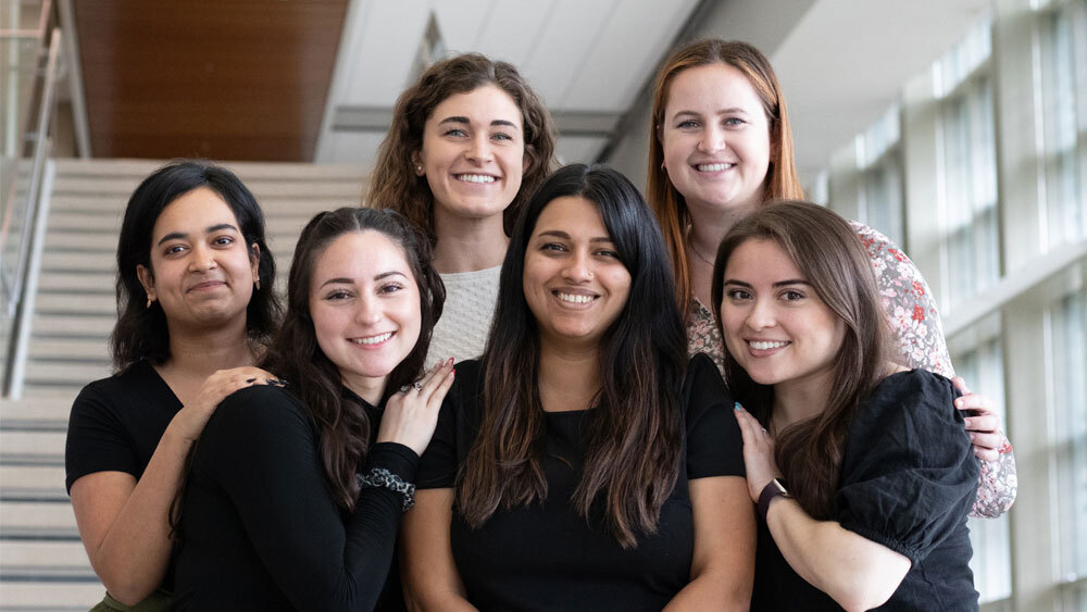 Dr. Raghavan stands on the stairs of the Emerging Technology Building with her lab students.