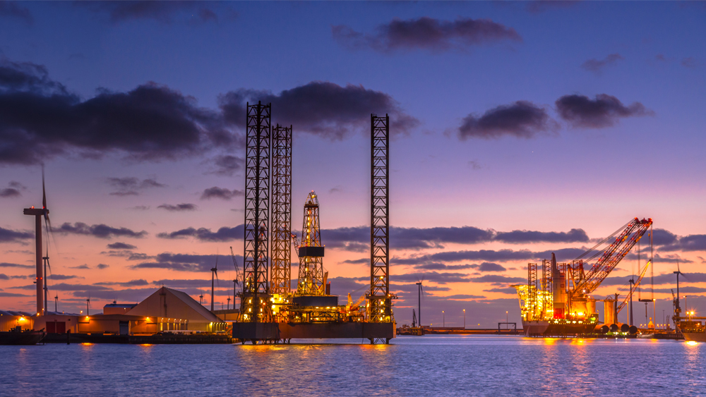 Panorama of Oil Platforms being built in a harbor under a sunset