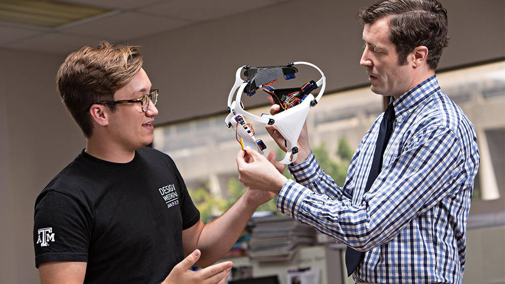 Image of a professor showing a student a research prototype.