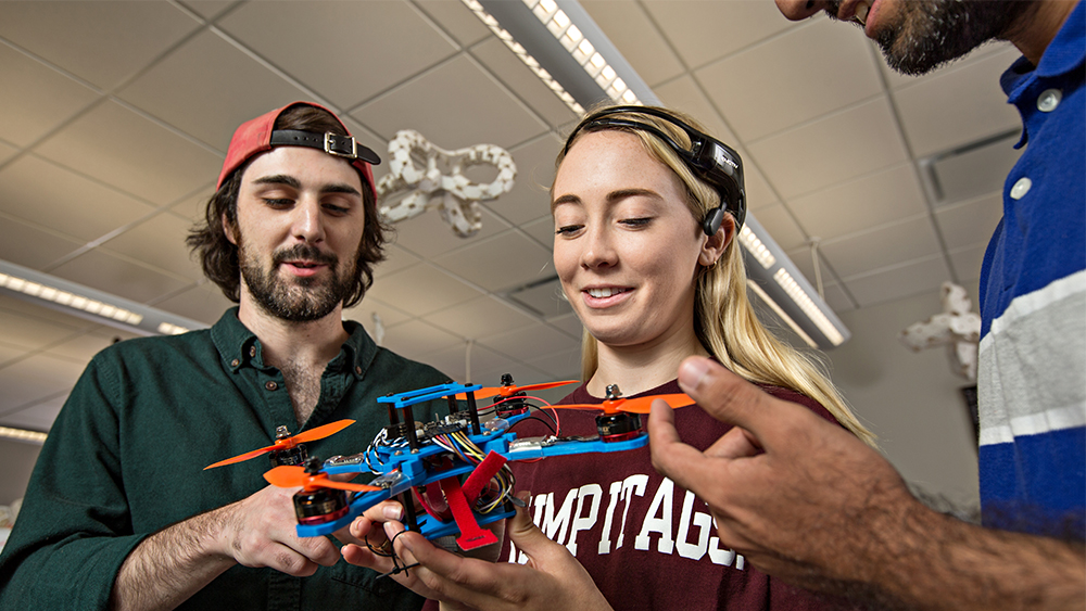 Image of students analyzing a drone.