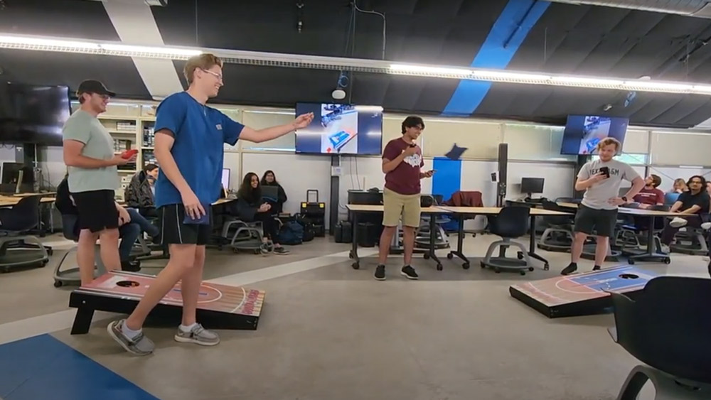 Capstone team testing their interactive cornhole board implementation