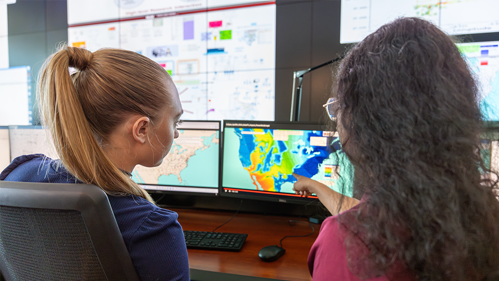 Two students looking at a computer screen with a heat map.
