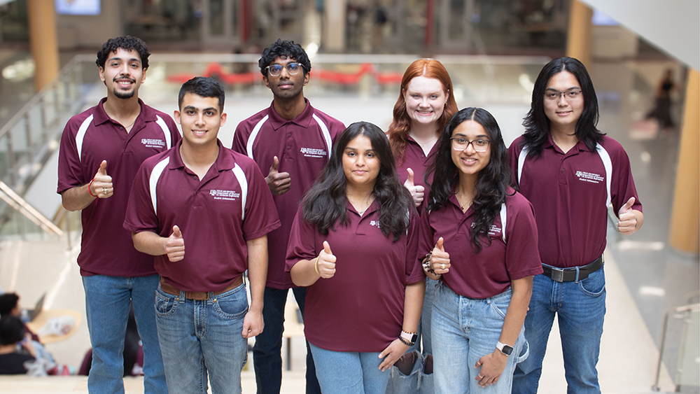 Seven students wearing identical shirts displaying the Texas A&M University Department of Electrical & Computer Engineering logo and the words Student Ambassadors.