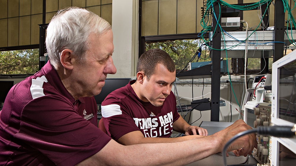 Faculty and student working on electrical equipment
