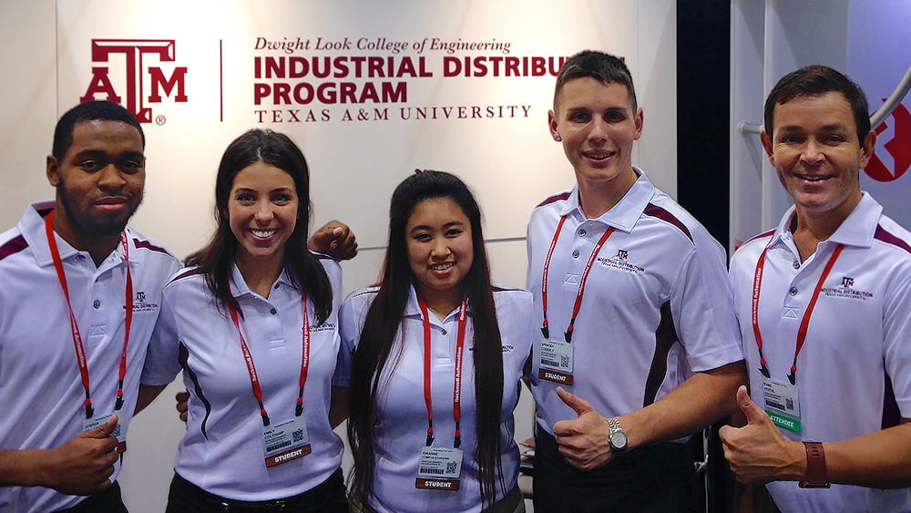 students in front of the Industrial Distribution conference booth