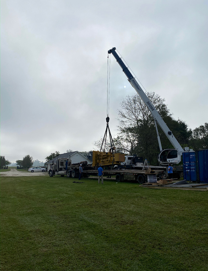 A crane lifting a generator into the yard. 