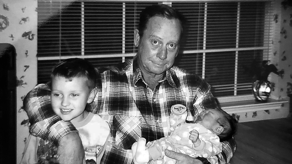 Carl Haynes holding his grandsons, Garrett O’Kelley ’16 and Keegan O’Kelley ’20.