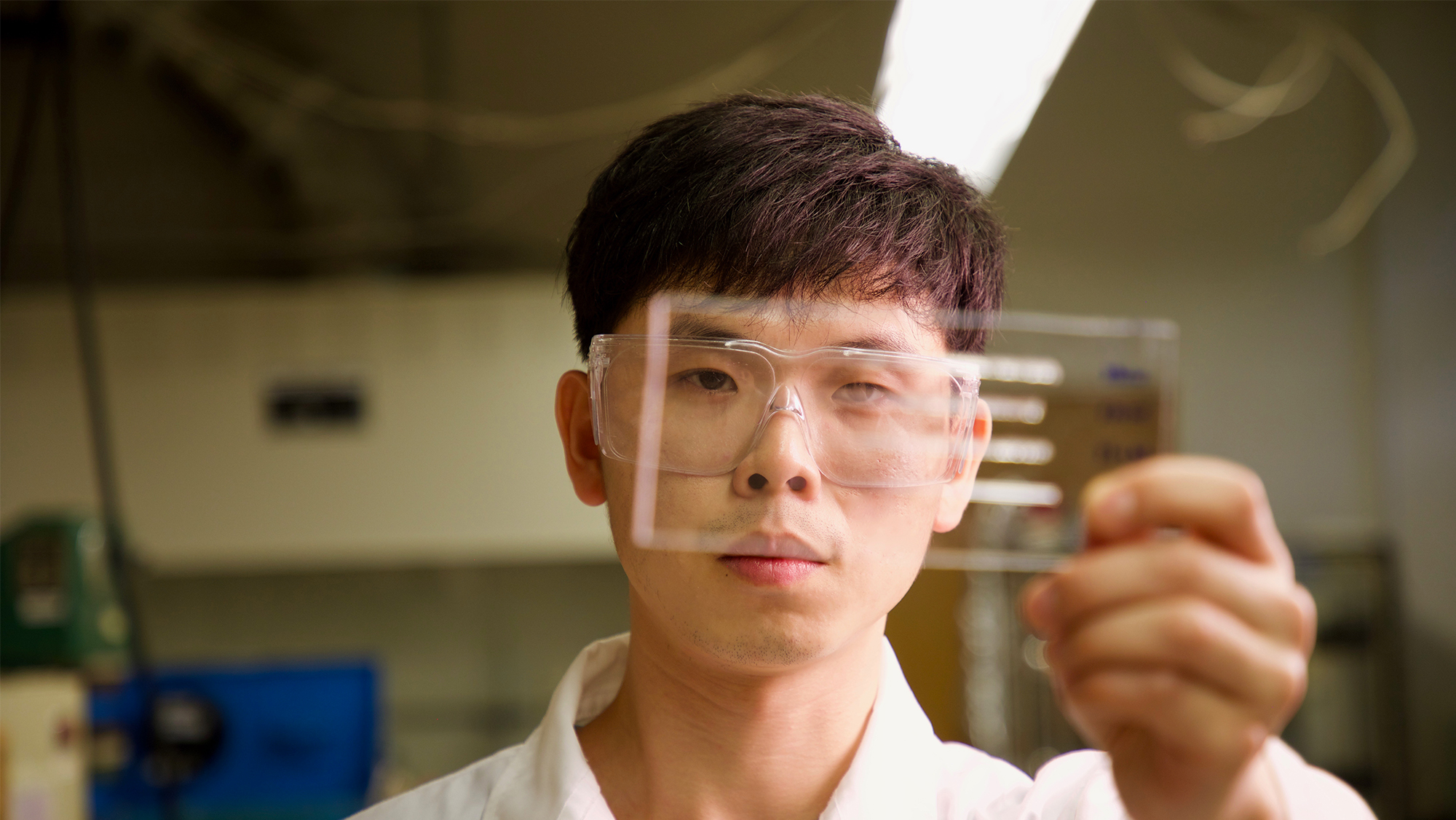 Student looks at a sample in the lab