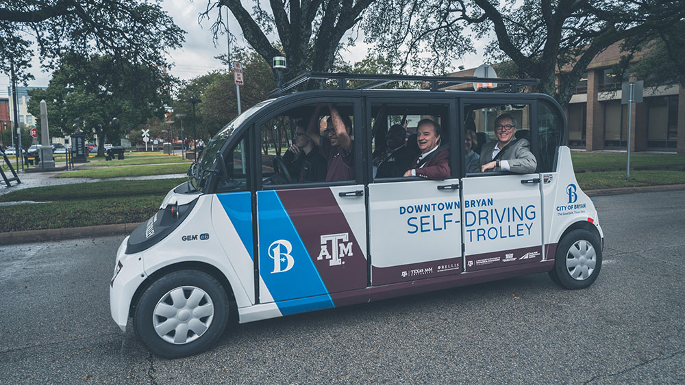 Dr. Sri Saripalli with Texas A&amp;M System Chancellor John Sharp, Bryan Mayor Andrew Nelson and others riding in an autonomous vehicle in Downtown Bryan.