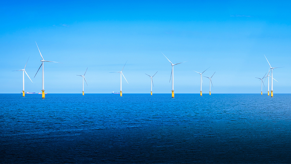 Offshore wind turbines standing in the ocean.