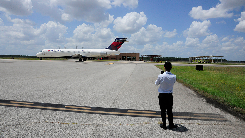 Giovanni Fuentes, an industrial and systems engineering undergraduate student, takes a photo of an airplane at his Houston Airport internship.