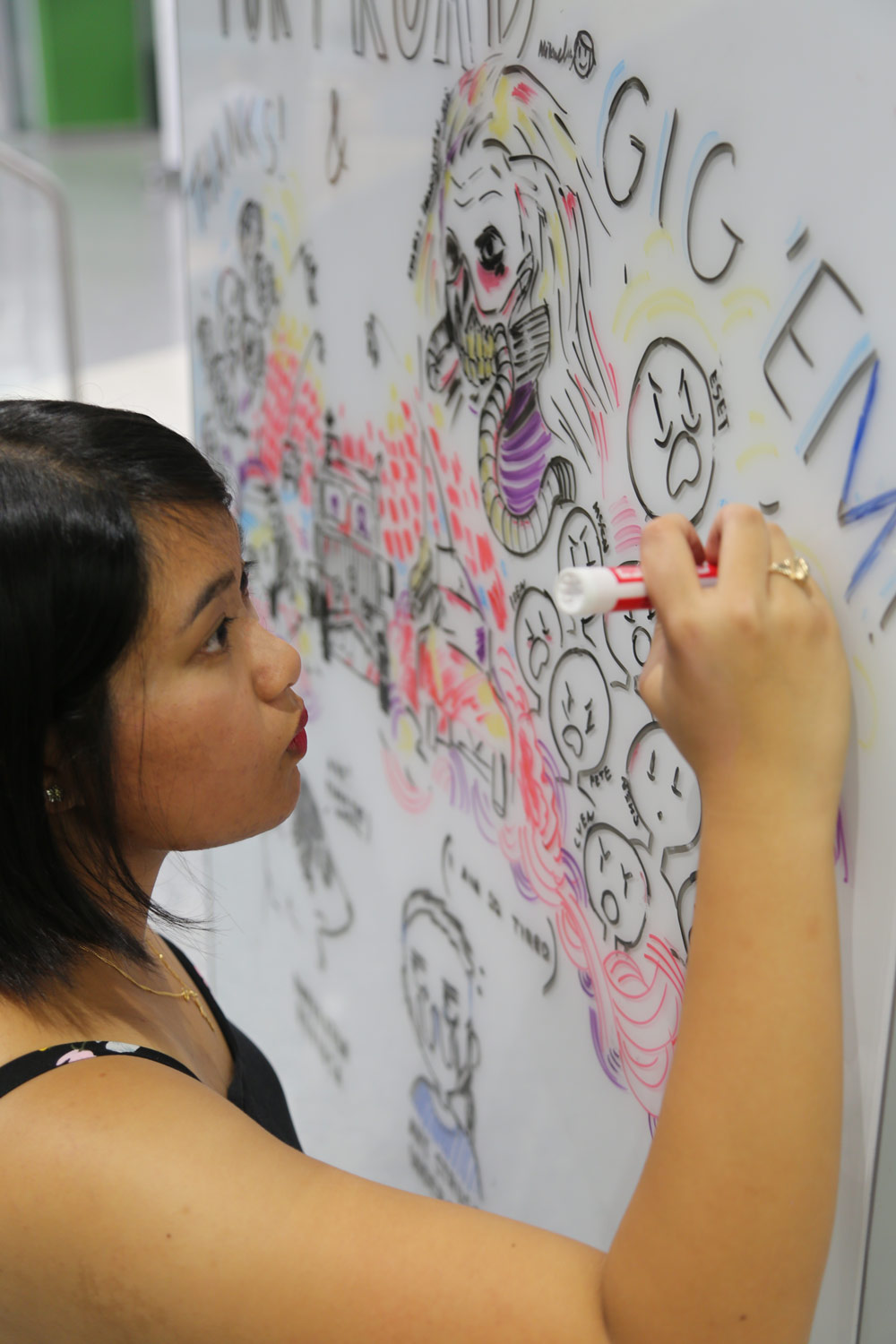 Student draws inspirational graphics on white board for fellow students.