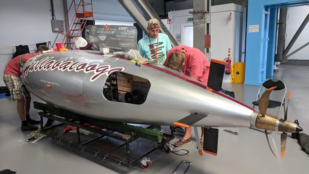 Human-powered submarine team members work on "Hullabalooga" to get the vehicle race-ready.