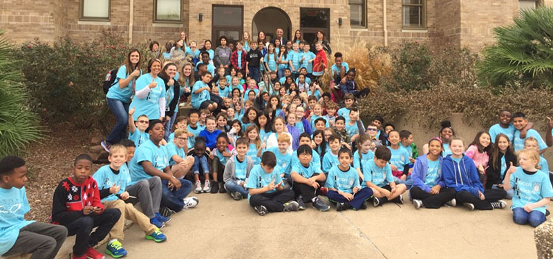 large group of fourth grade students seated and standing on steps outside Fermier Hall on Texas A&amp;M campus