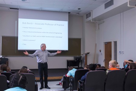 Industrial engineering professor Bob Borsh stands in front of fourth grade students and shows how toys go through design and manufacture processes