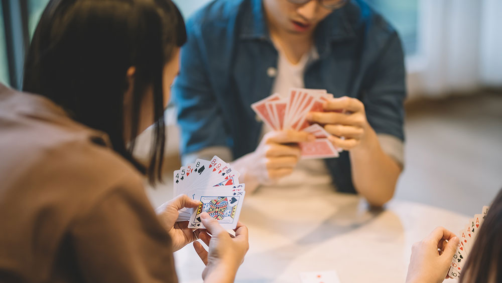 Image of friends playing a card game