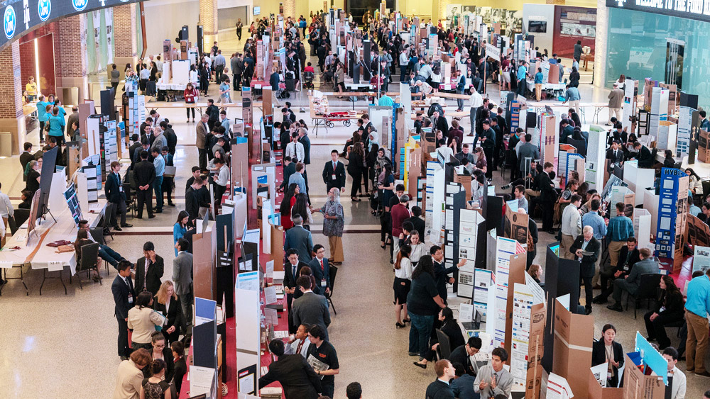 Aerial view of students presenting their poster board projects to judges at the Ford Hall of Champions in Kyle Field during the 2019 Texas Science and Engineering Fair.