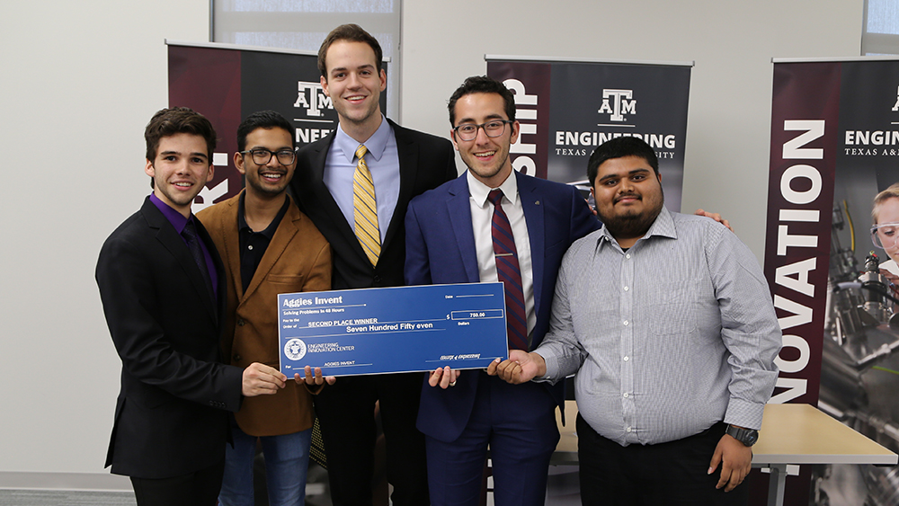 Five male students hold second place check. 