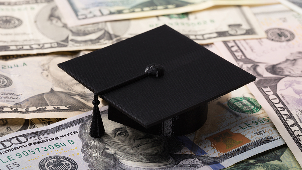 graduation cap on top of cash