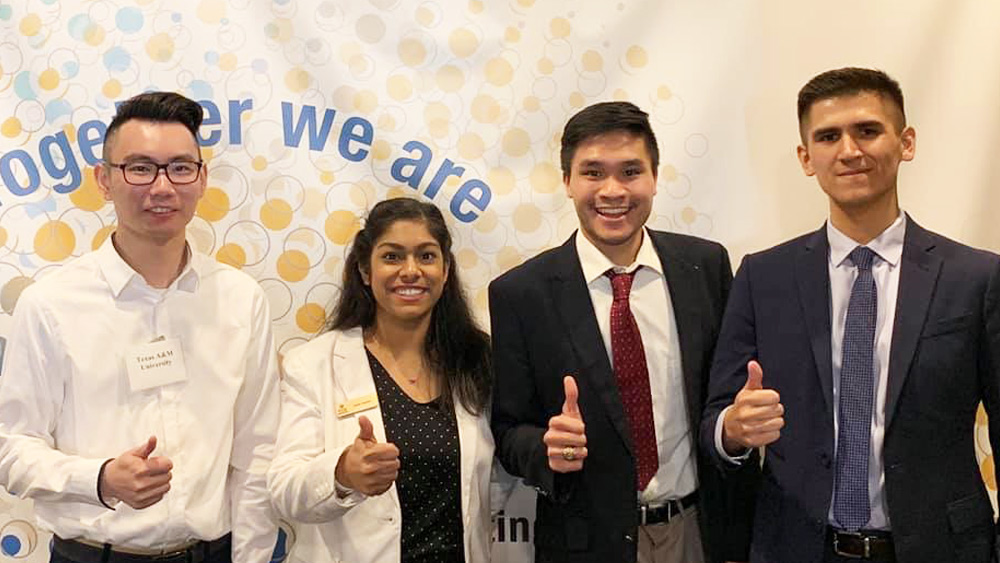 Student team posing for camera in front of banner at the Global Grand Challenges Summit 2019