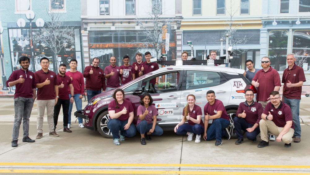 The 2019 AutoDrive team from Texas A&M with their autonomous vehicle