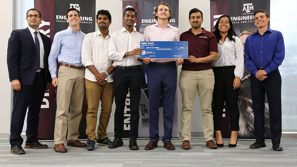 The Aggies Invent first place team poses with their check.