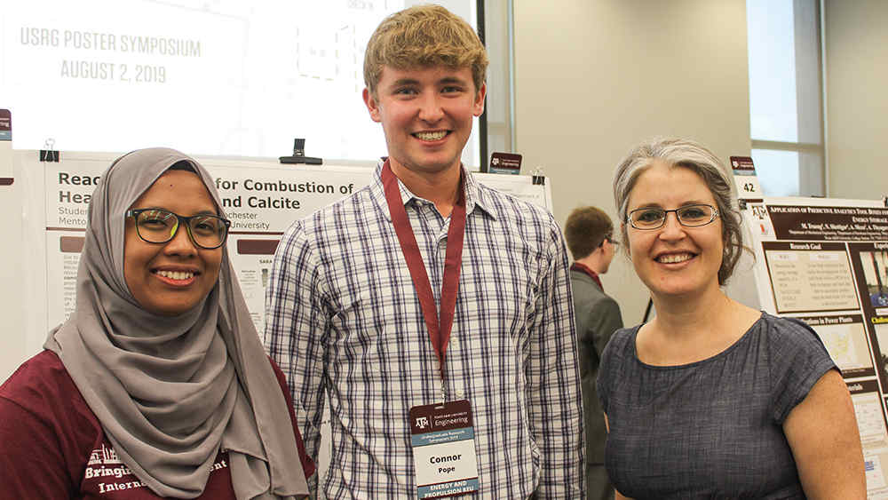 graduate student Norasylkin Ismail, undergraduate student Conner Pope, and Texas A&M petroleum engineering faculty member Dr. Berna Hascakir standing together and smiling during August 2, 2019 poster symposium