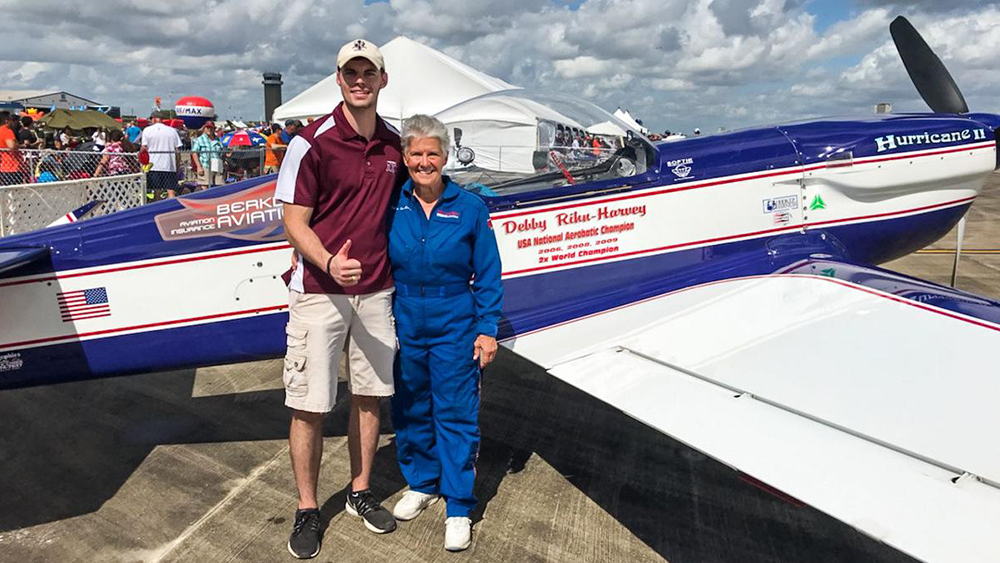 Texas A&amp;M University Aerospace Engineering student, Jacob Collins, poses with Debby Rihn-Harvey in front of her plane at the Wings Over Houston Airshow.