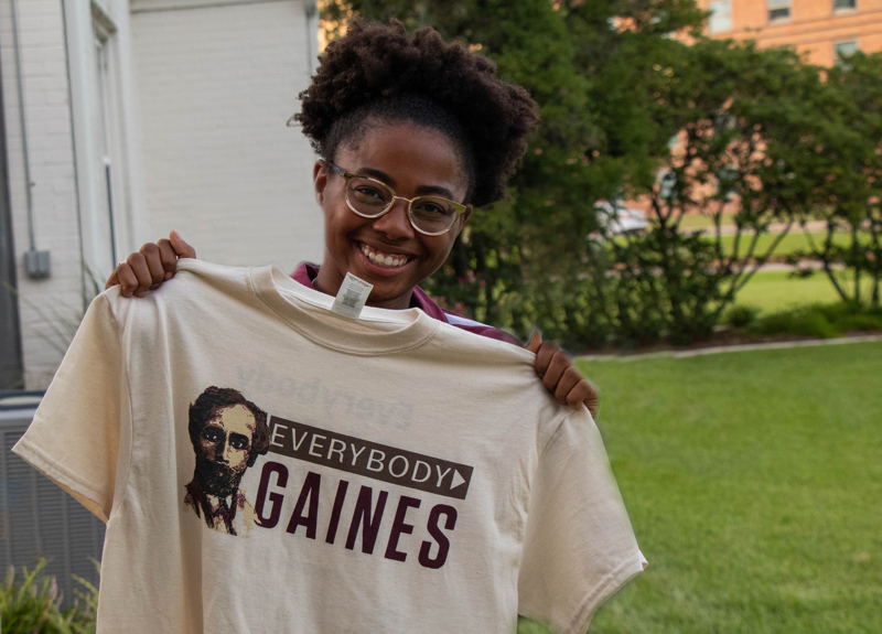 Student holds a t-shirt for the Everybody Gaines initiative. 