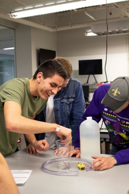 Diego Sol, left, reacts to the sensor his team designed as the dip it into the vinegar.