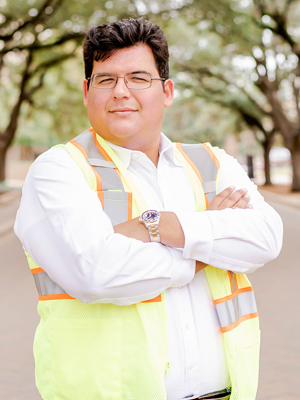 Civil Engineering graduate Andrew Salazar standing with his arms crossed wearing a construction vest
