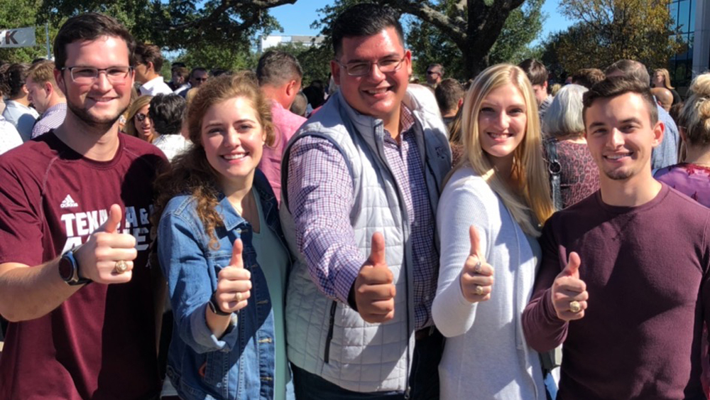 A group of students smiling with a thumbs up 