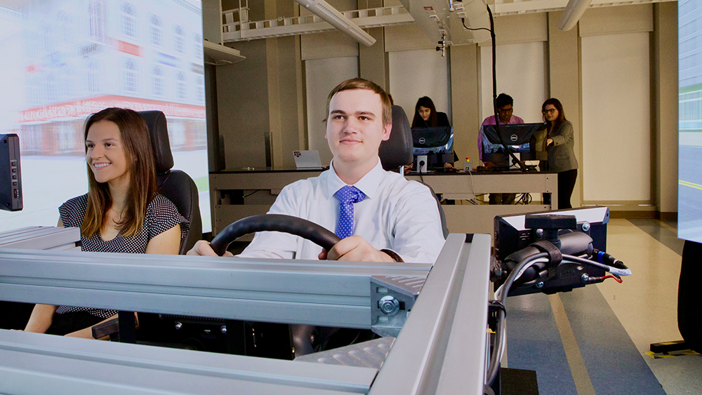 Two students driving in the driving simulator. 