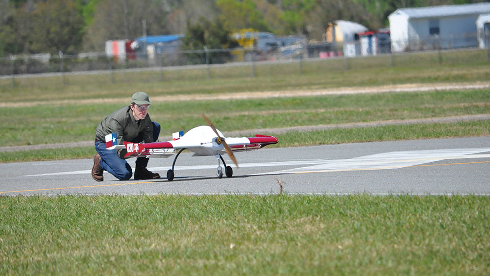 TAMU SAE team director Jack Kassing preparing aircraft for a flight test on the runway.